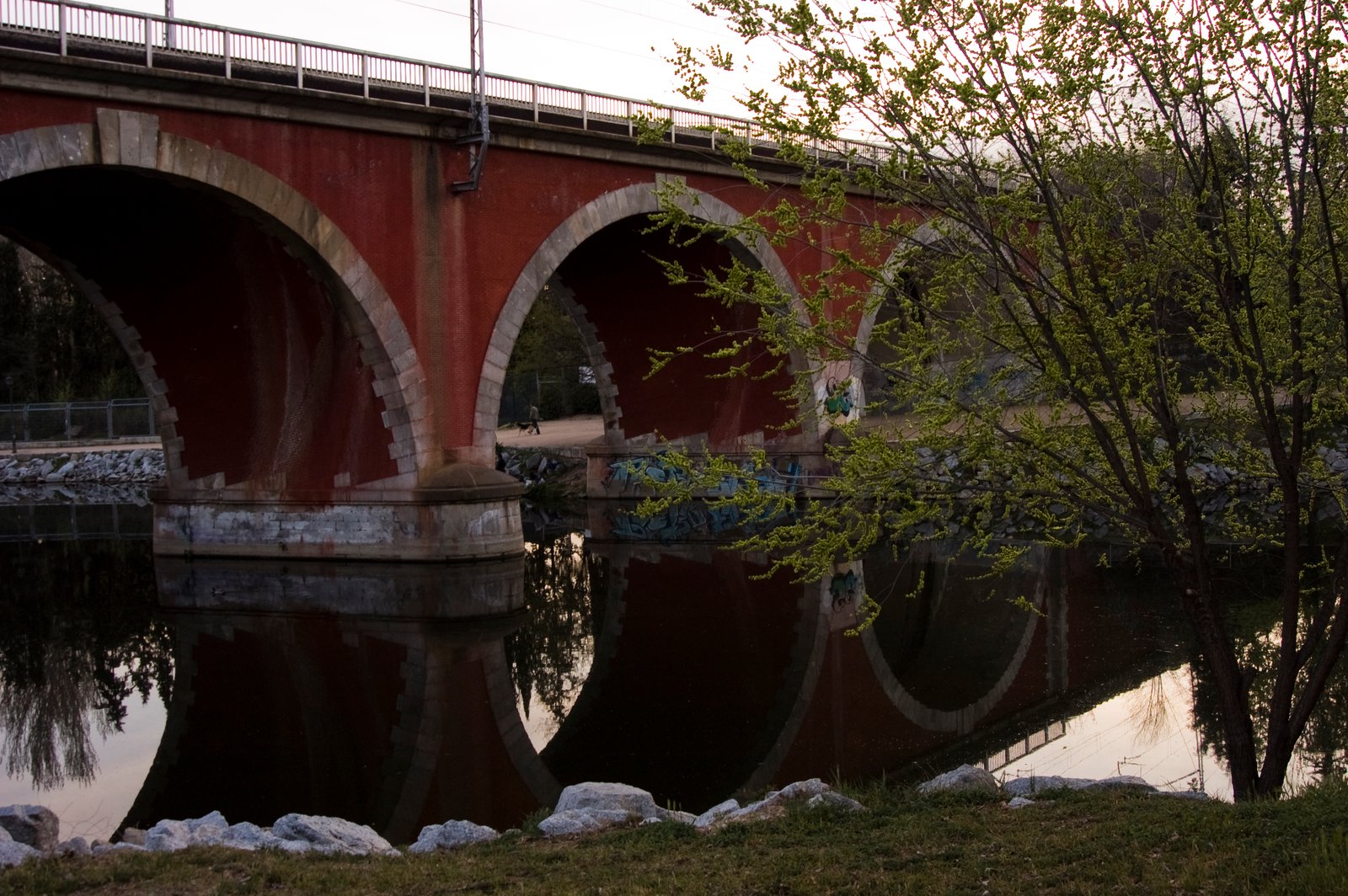 Los arcos de ladrillo del Puente de los Franceses reflejados en el río Manzanares.