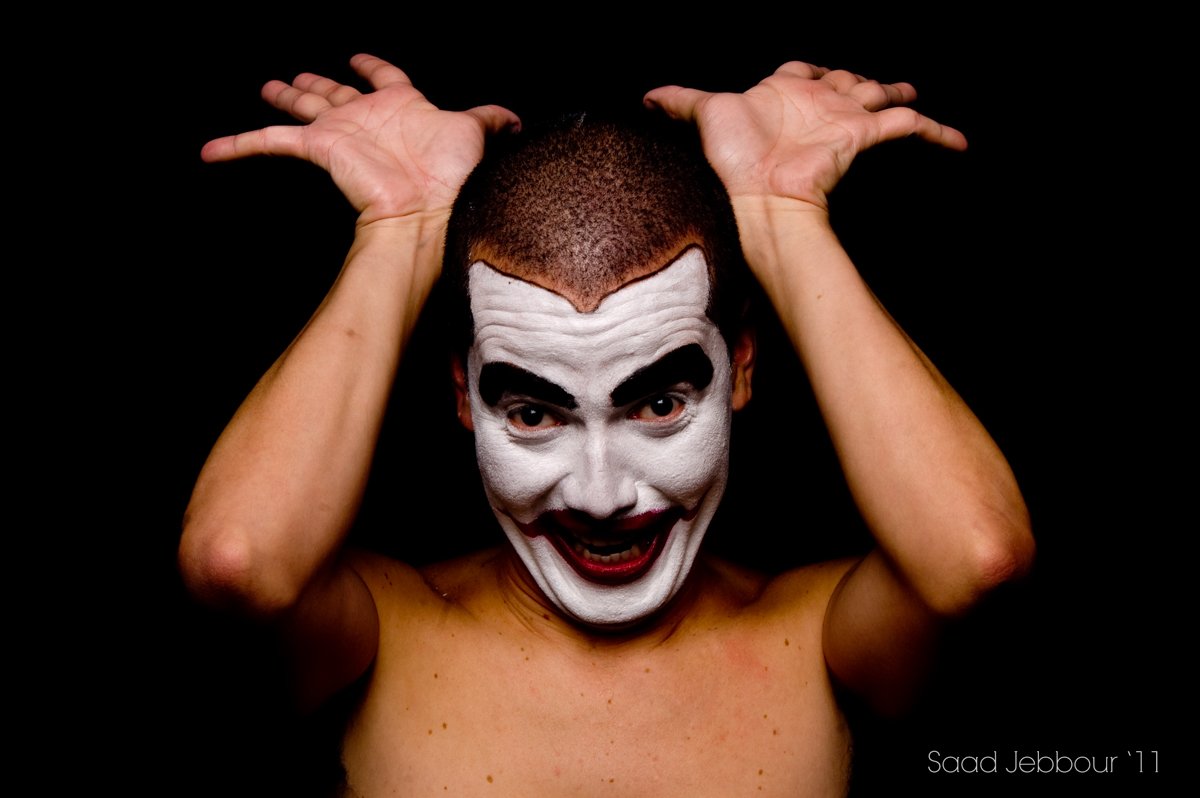El payaso sonríe con los brazos apoyados sobre la cabeza.
